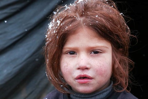 Displaced Syrian families and children living in refugee camps during harsh winter conditions,