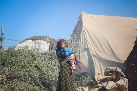 A Syrian refugee child photographed in a camp, reflecting the harsh living conditions of displaced