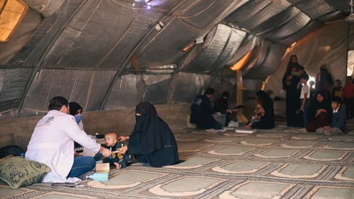 A doctor examining a woman inside a mobile medical point dedicated to treating Syrian refugees.