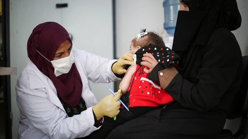 A doctor examines children's malnutrition inside a refugee camp. Malnutrition was measured using a