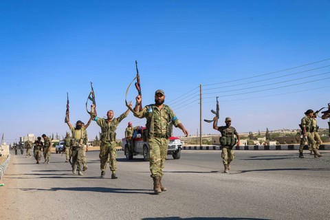 Fighters from the Free Syrian Army celebrate victory after capturing villages that were under the