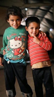A Syrian refugee child photographed in a camp, reflecting the harsh living conditions of displaced