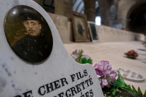 WWI soldier's portrait at necropolis with graves of Belgian World War One soldiers buried in the