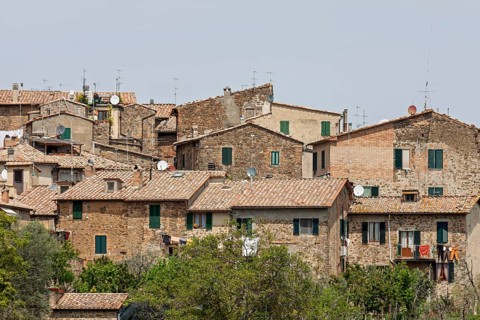 Houses with tiled roofs and antennas, surrounded by green vegetation, in a Mediterranean, rustic