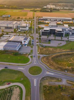 Overview of a roundabout in an industrial area, surrounded by fields and buildings, industrial area