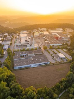 Industrial area surrounded by forests and hills in the evening light of the sunset, industrial area