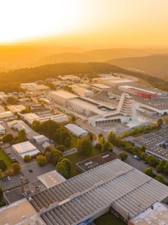 Industrial complex at sunset surrounded by hills and forests, industrial area Wolfsberg Nagold,