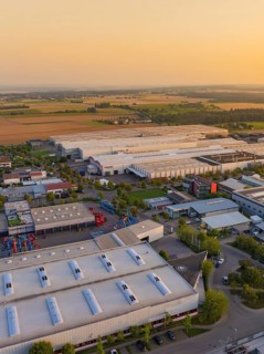 Industrial buildings and roads near fields with vehicles and urban development, Wolfsberg Nagold