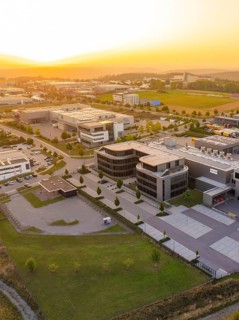 Modern commercial building with car park in a rural setting at sunset, industrial area Wolfsberg