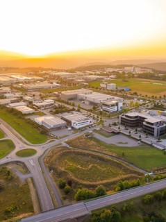 Industrial area in the sunset, surrounded by fields and forests with modern buildings, industrial