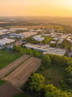 Aerial view of a rural industrial plant with fields and trees at sunset, industrial area Wolfsberg