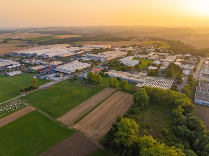 Industrial warehouses and fields in a vast rural landscape at sunset, Wolfsberg Nagold industrial