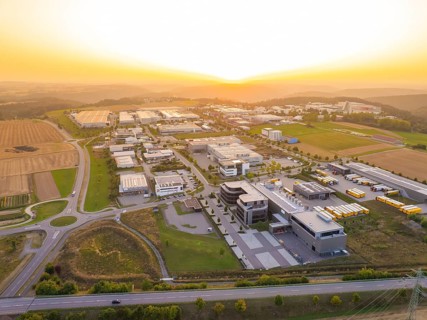 Industrial park at sunset, with symmetrical streets and a mixture of fields and buildings,