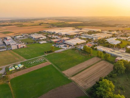 View of an industrial area surrounded by agricultural land in the evening light, Wolfsberg Nagold