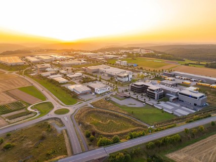 Wide view of an industrial area at sunset, surrounded by fields and forests, industrial area