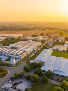 Industrial area at sunset with fields and green areas in the background, industrial area Wolfsberg