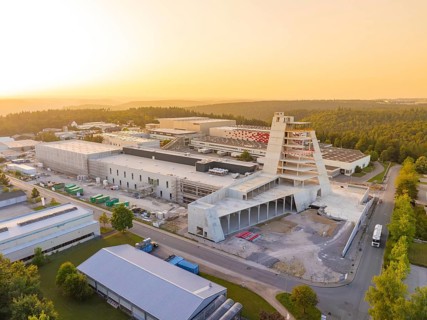 Striking modern industrial building in the surroundings of a large industrial complex at sunset,