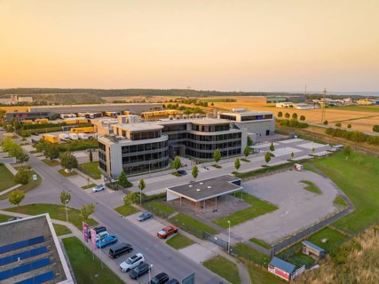 Modern office buildings and car parks in an urban setting at sunset, Wolfsberg Nagold industrial