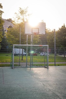 An outdoor basketball court with a basket and sunlight in the background, Nagold, district of Calw,