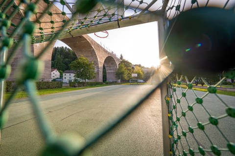 Playground with basketball hoop and a large bridge in the evening sunlight, Nagold, Calw district,