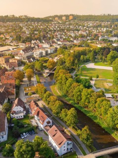 View of a town with river, surrounded by trees and green areas in autumnal splendour, Nagold,