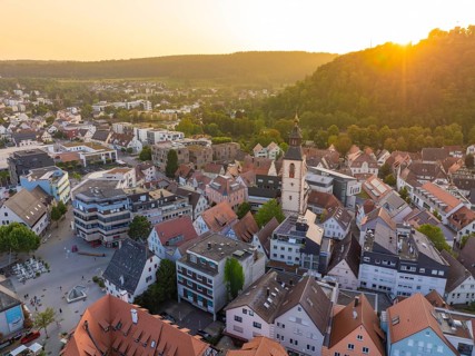 Evening view of an old town with church tower, surrounded by nature and hills, Nagold, district of