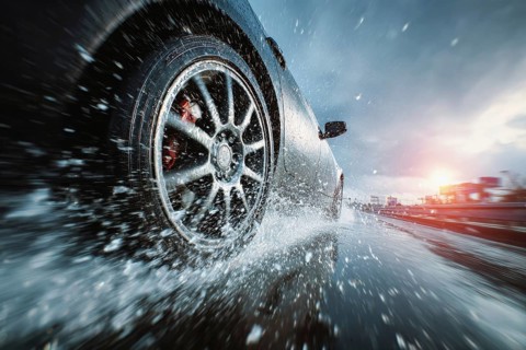 Car drives fast on a wet road, motorway, motorway and generates splash water, risk of accident due
