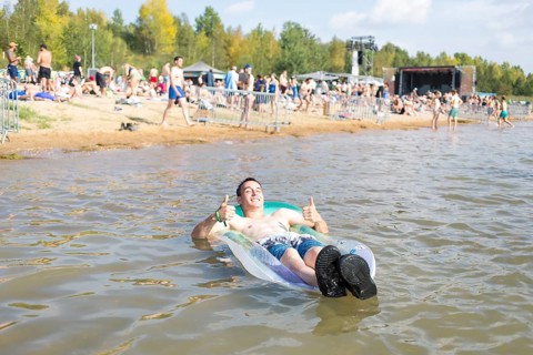 Festival visitor Sven lies on an air mattress in Lake Störmthal at the Highfield Festival on