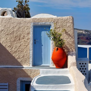 Red vase in front of a yellow wall, light blue door, holiday home, Oia, Thira, Santorini, Cyclades,