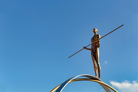 Sculpture Balance by the artist Martina Ondáková in front of a blue sky, human figure balanced,