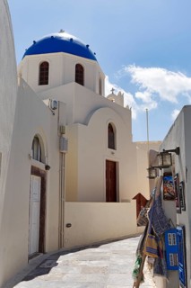 Orthodox church with blue dome in a narrow alley, shopping in the old town, Oia, Thira, Santorini,