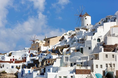 Whitewashed holiday homes, two windmills on the hillside, Cumulus, Oia, Thira, Santorini, Cyclades,