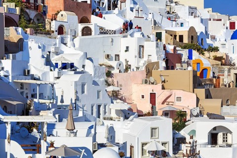 White and colourfully painted holiday homes on a steep slope, narrow alleys, Oia, Thira, Santorini,