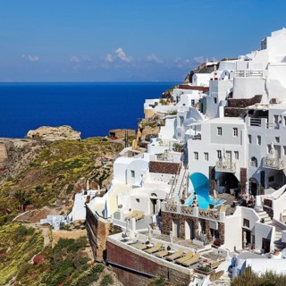 White holiday homes on the edge of the caldera overlooking the sea, Oia, Thira, Santorini,