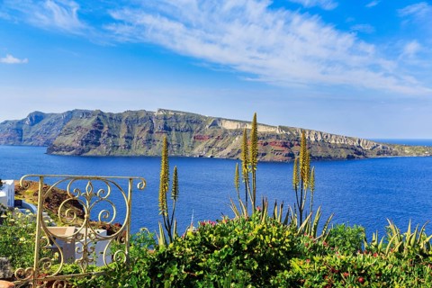 Wrought-iron railing, Mediterranean vegetation, view of the caldera and the island of Nea Kameni,