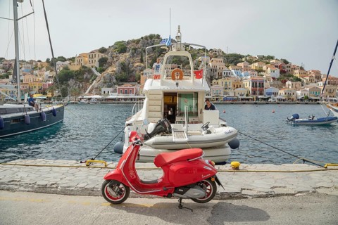 Red vespa scooter parked at Gialos harbour, Gialos, Symi Island, Dodecanese Islands, Greece