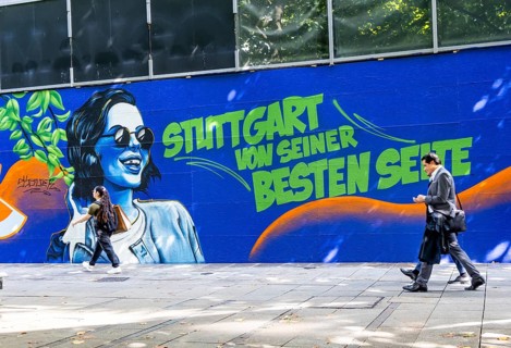 People on the move in the Königstraße pedestrian zone in Stuttgart. Construction fence with the