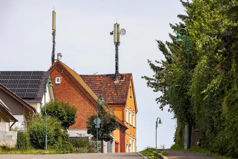 Mobile phone mast on a house roof in a rural area. Ohmden, Baden-Württemberg, Germany