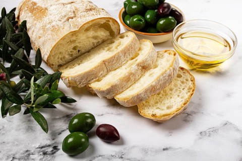 Appetizer, sliced ciabatta bread, with olive oil, green olives, Chalkidiki olives, classic Green