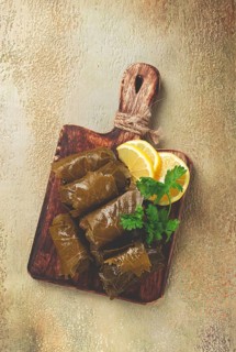 Dolma, minced meat with rice, in grape leaves, minced meat rolls, on a chopping board, top view, no