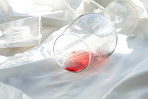 Glass, with pink wine, spilled on a white shirt, close-up, selective focus, no people, concept, top