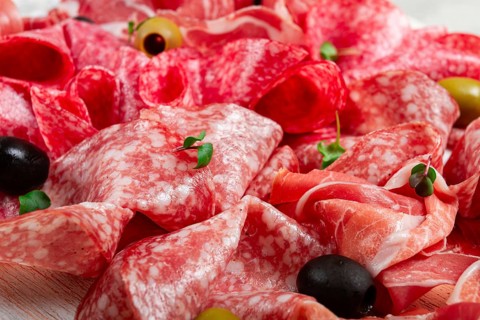 Assorted, meat appetizer, prosciutto, salami and ham, with olives, close-up, breakfast, top view,