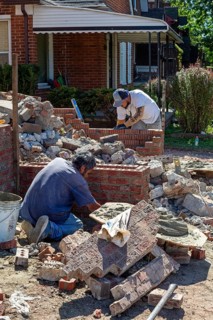 Detroit, Michigan - Workers rebuild the front porch of a house they are remodeling in the
