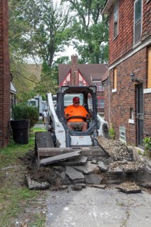 Detroit, Michigan - Workers replace an old driveway, part of remodeling a house in the Morningside