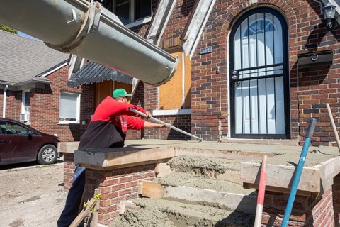 Detroit, Michigan, Workers rebuild the front porch of a house they are remodeling in the