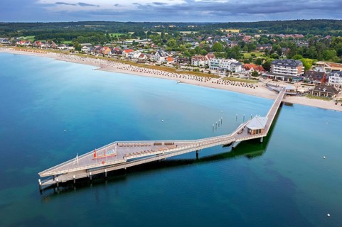Aerial view over Seebrücke, pier and sandy beach at seaside resort Haffkrug along the Baltic Sea,