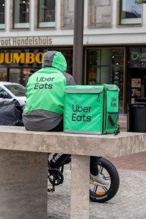 Bicycle transport in Groningen, Uber Eats, courier driver waiting for new orders, with e-bike in