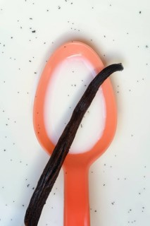 Spoon with vanilla pod, vanilla seeds in milk