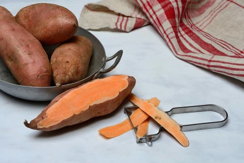 Sweet potatoes in skin and potato peeler, Ipomoea batatas