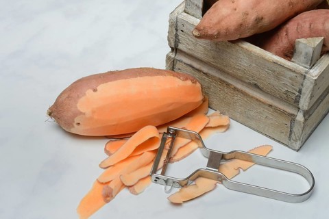 Sweet potato with vegetable peeler, partly peeled, Ipomoea batatas